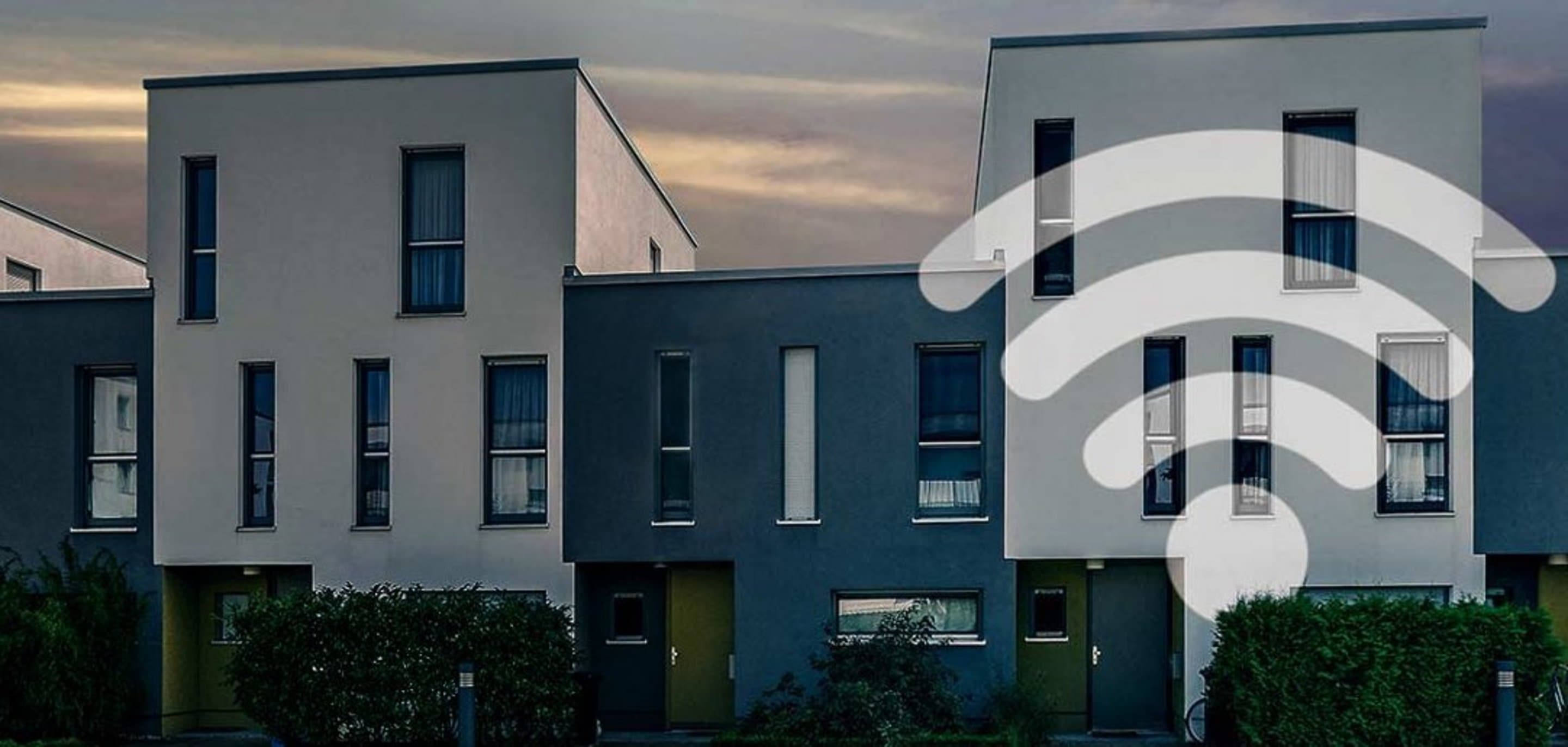 Häuserfront auf der ein WLAN-Symbol abgebildet ist.