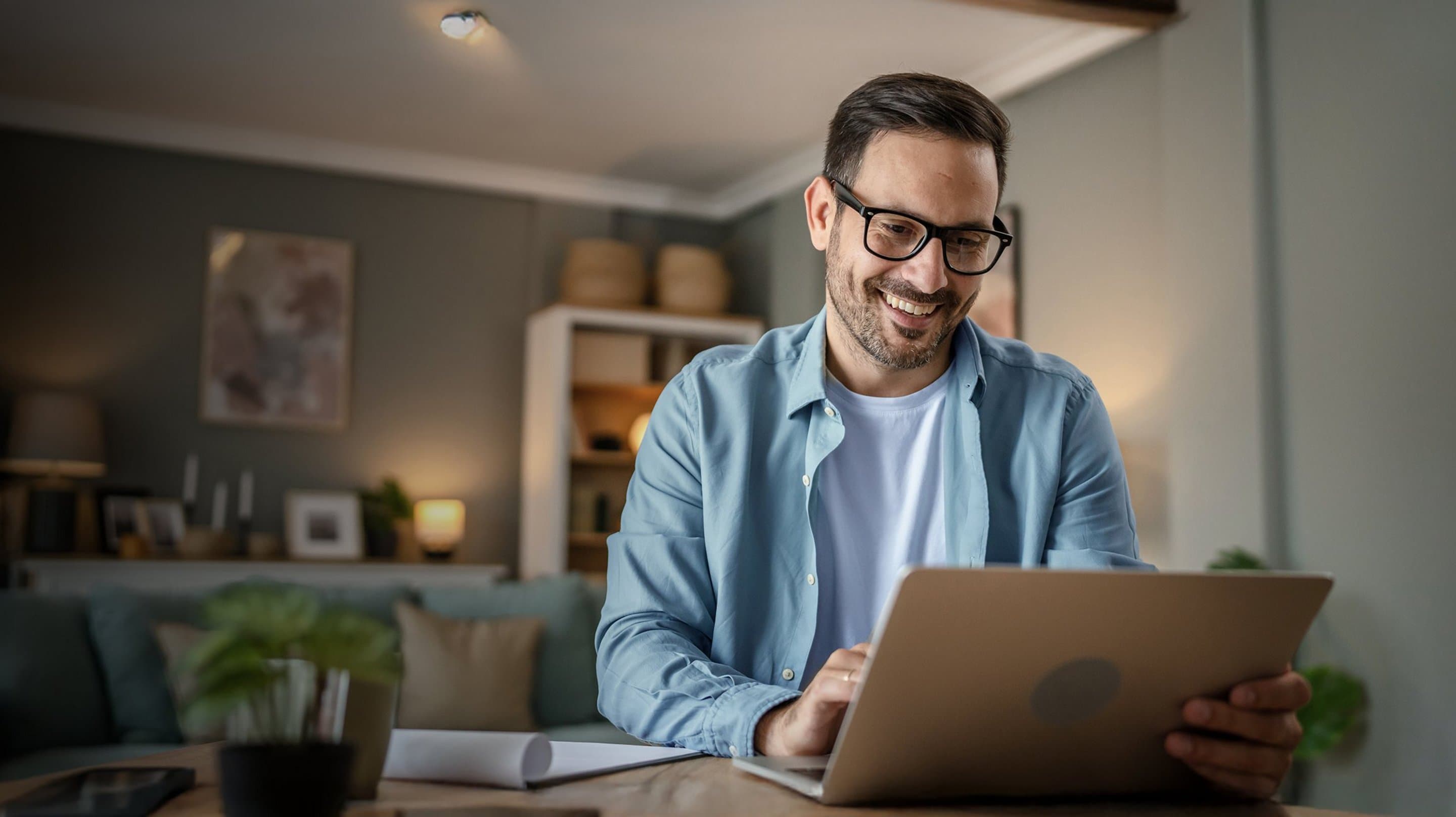 NetAachen Hilfe Mann sitzt am Tisch vor aufgeklapptem Laptop
